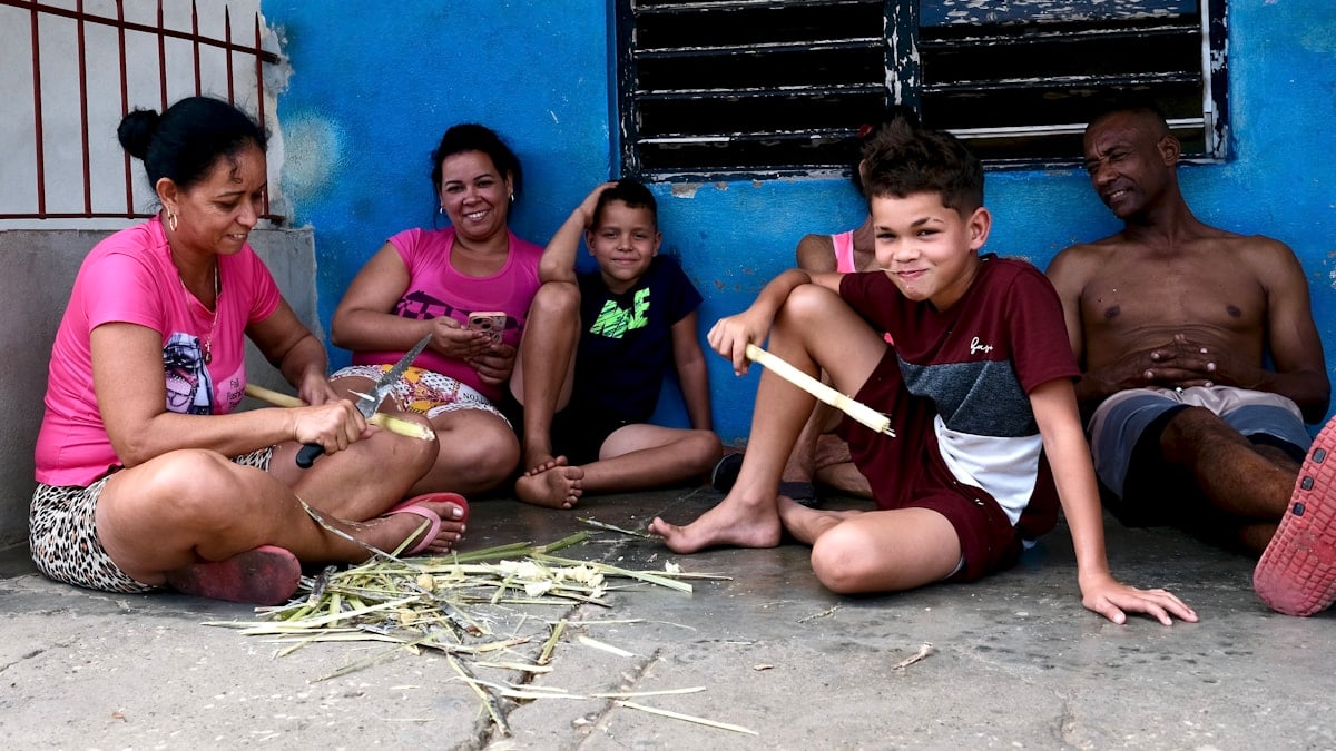 Family sitting together on the ground outside.